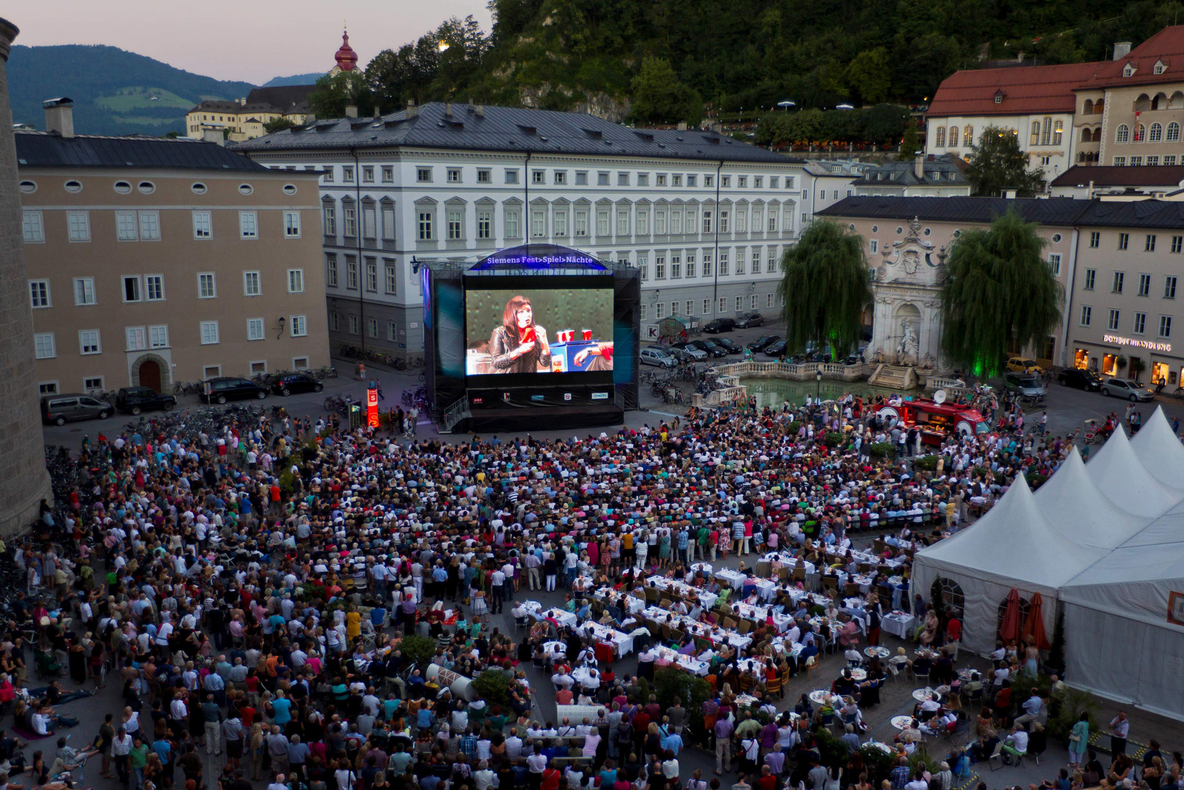 Foto von Videowall mit Publikum im Vordergrund.