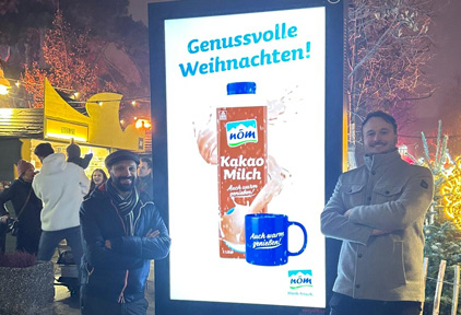 Outdoor Monitor im Hochformat mit Werbung von der Firma NÖM zu Weihnachten