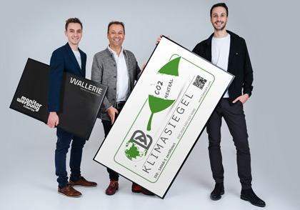 David, Andreas und Sebastian Lanner mit dem Klimasiegel  in einem Monitor