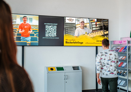 Foto von Indoor-Screen in der FH Kärnten in Villach mit dem Lehrlings-Sujet von Wienerroither