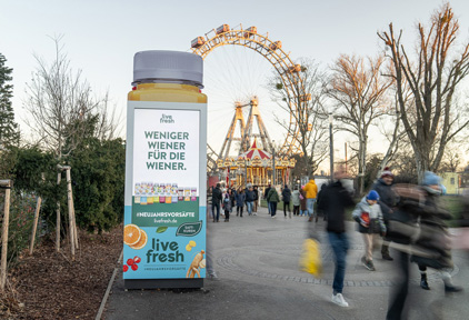 Hochformatiger Outdoor Screen mit Formatsprengung als Flasche und Wiener Riesenrad im Hintergrund